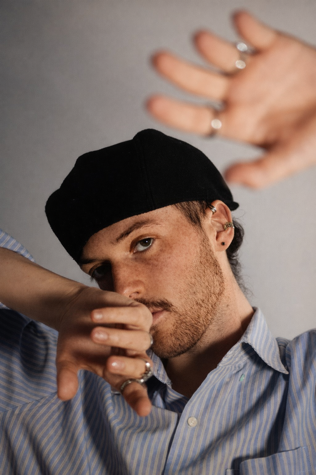 George Butler, a professional dancer with freckles and short facial hair, photographed in both expressive studio portraits and dynamic contemporary dance movement.