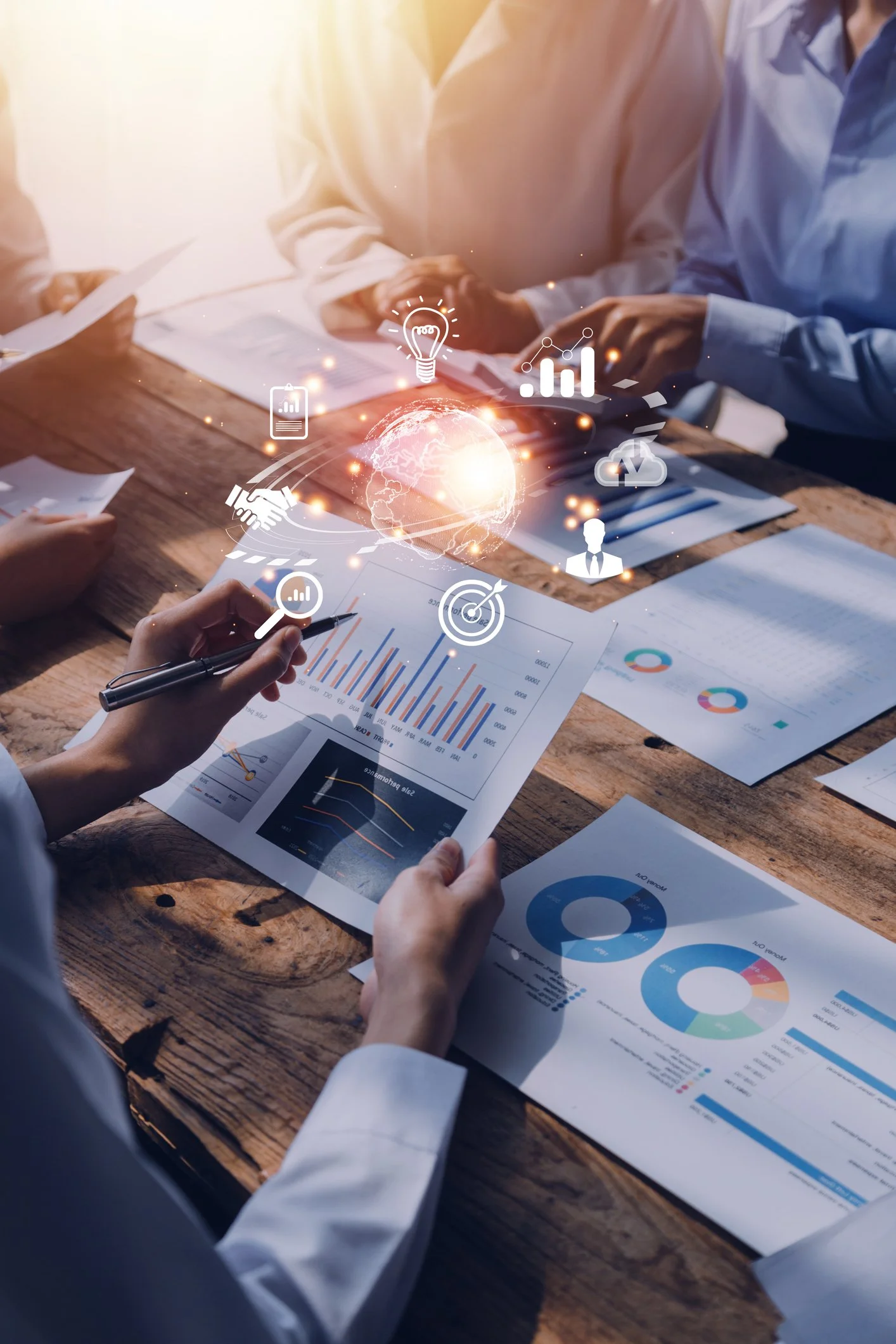 Business meeting with charts, graphs, and digital icons representing data analysis and global connectivity.