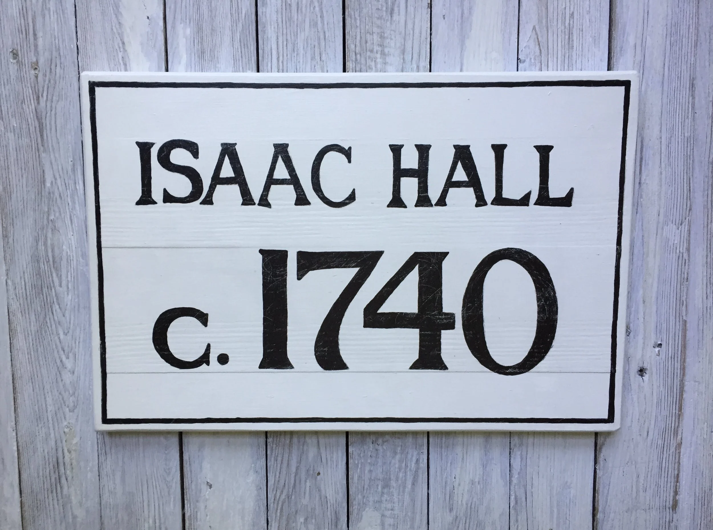 White wooden sign with black text reading 'ISAAC HALL c. 1740' 