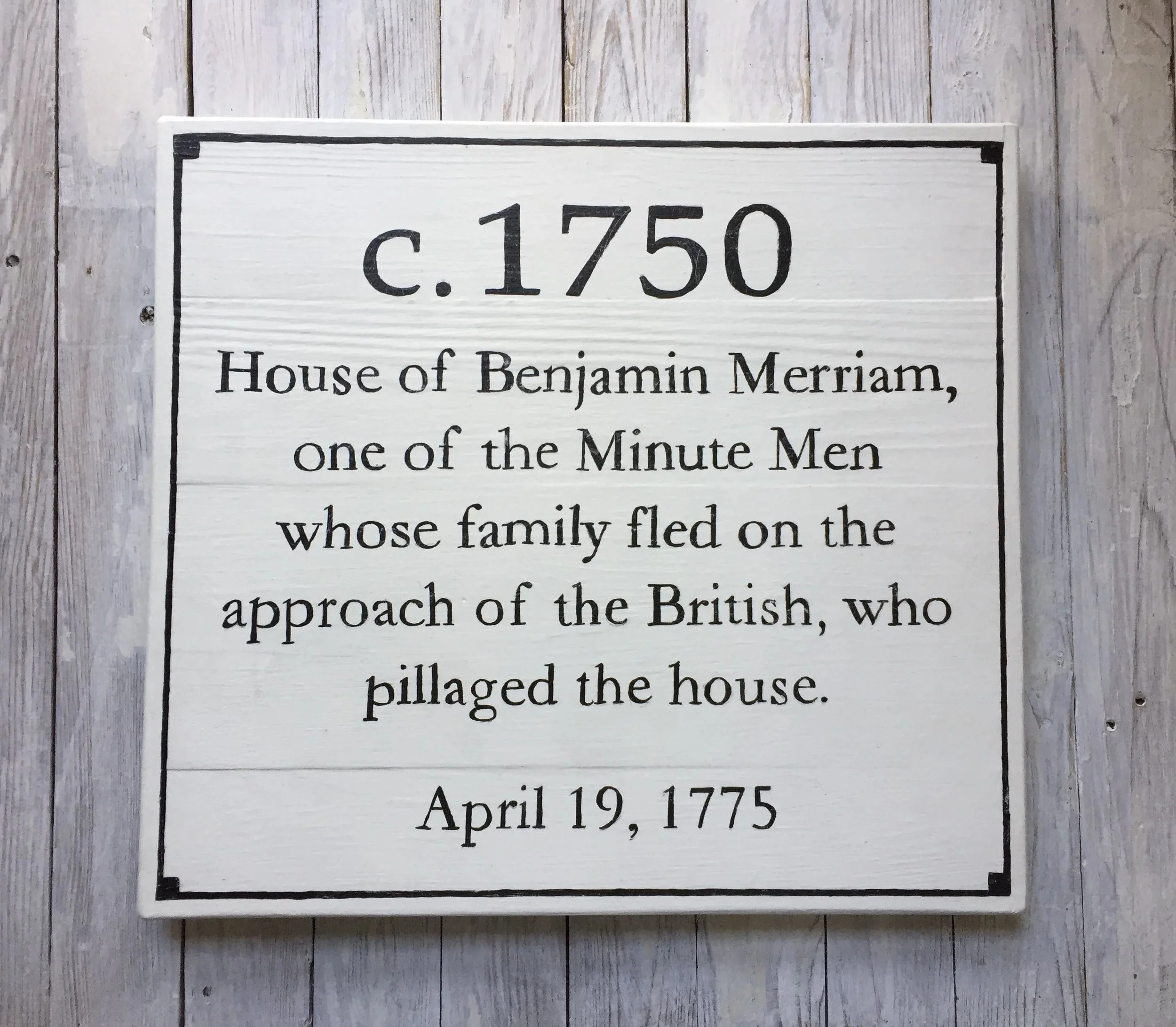 Wooden plaque describing the House of Benjamin Merriam, a Minute Man family, built around 1750 and pillaged by the British in 1775.