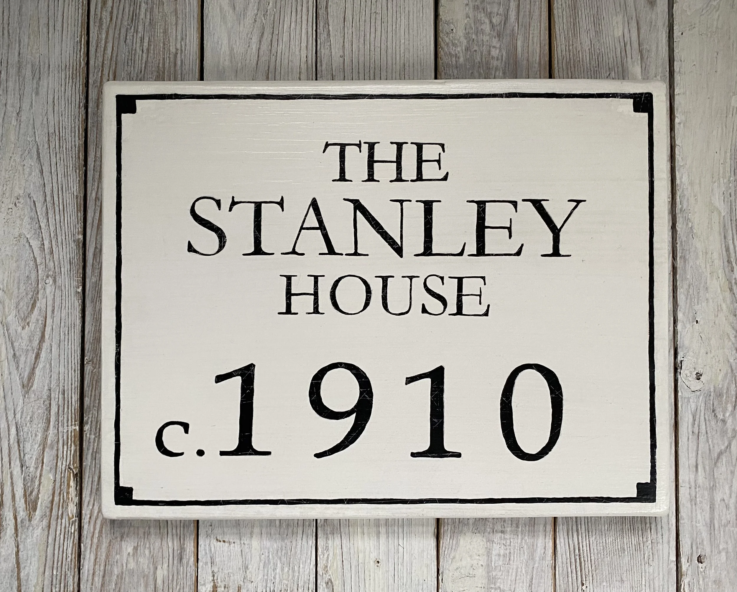 A square sign with black border and black text reading 'The Stanley House c. 1910'