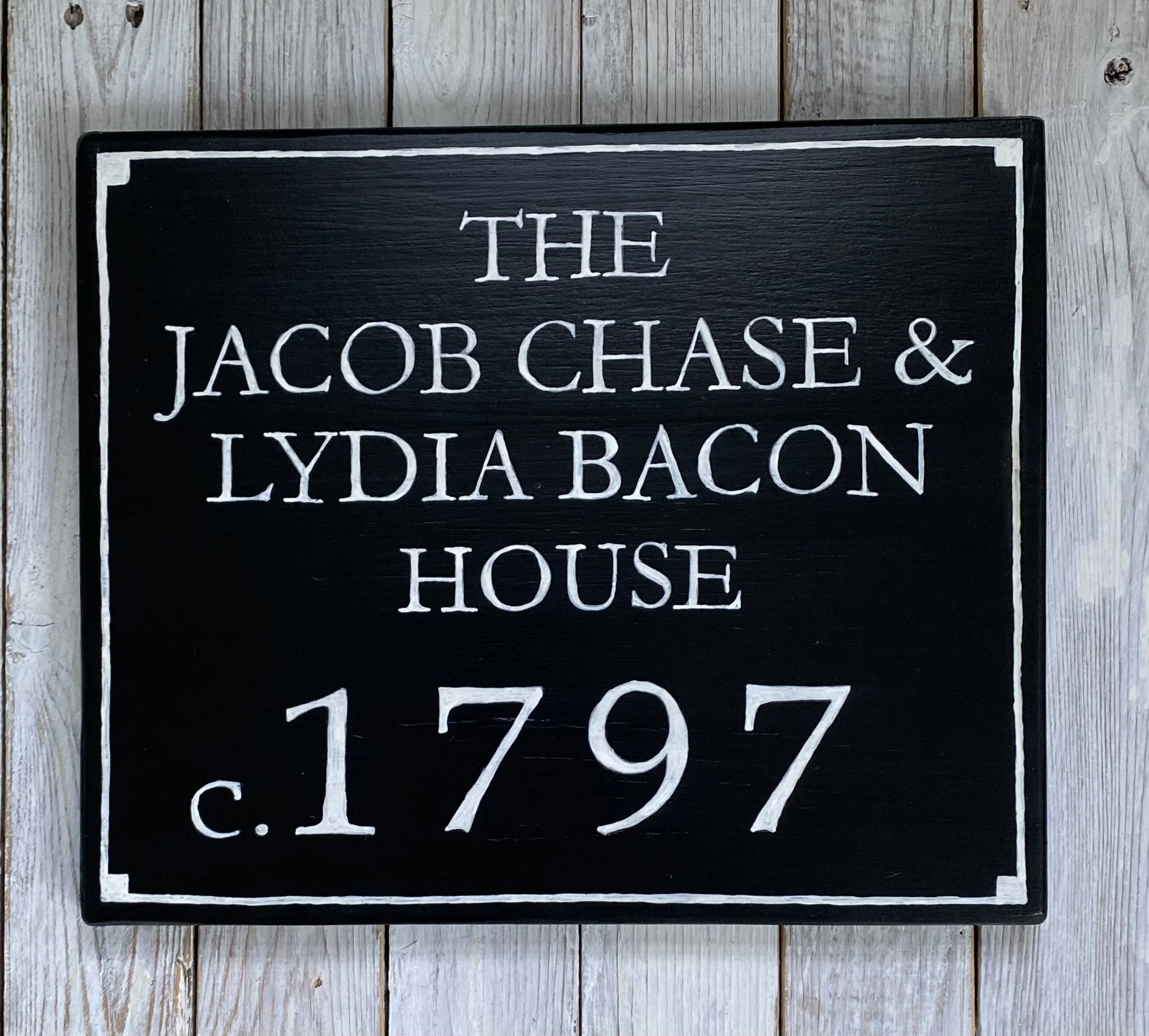Black sign with white text reading "The Jacob Chase & Lydia Bacon House c. 1797" 