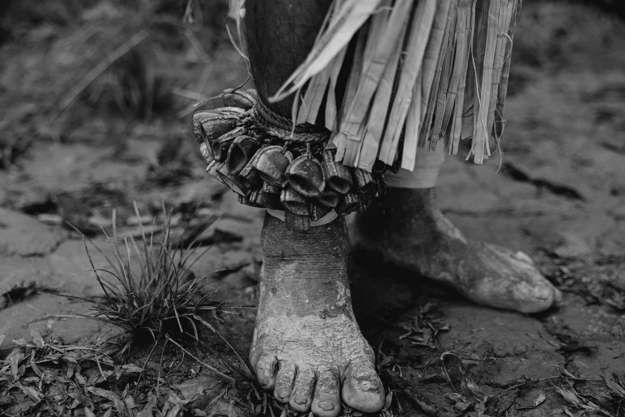 Schwarzweißaufnahme nackter Füße im Gras.