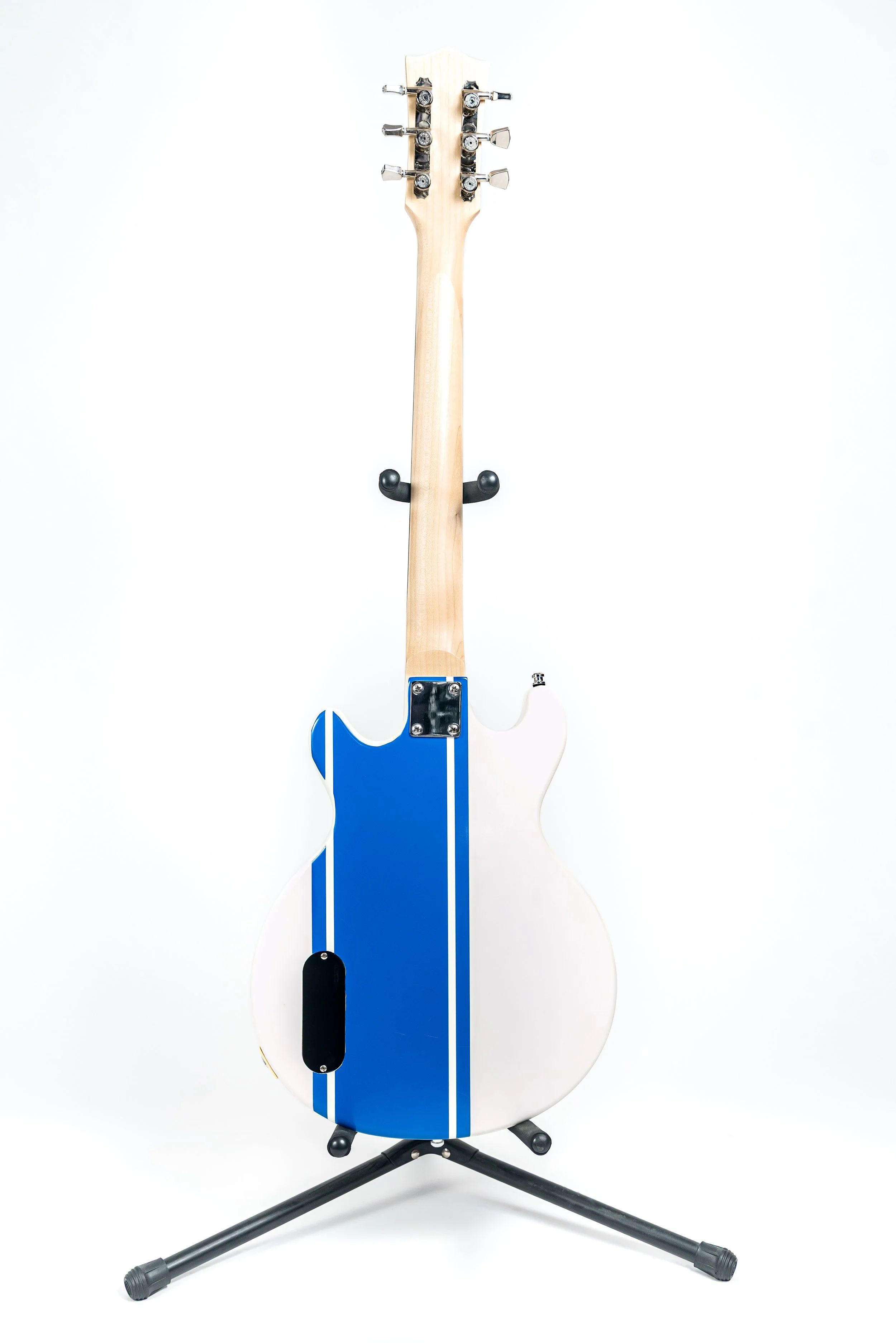 An electric guitar standing on a black tripod guitar stand against a white background, with its back side visible.