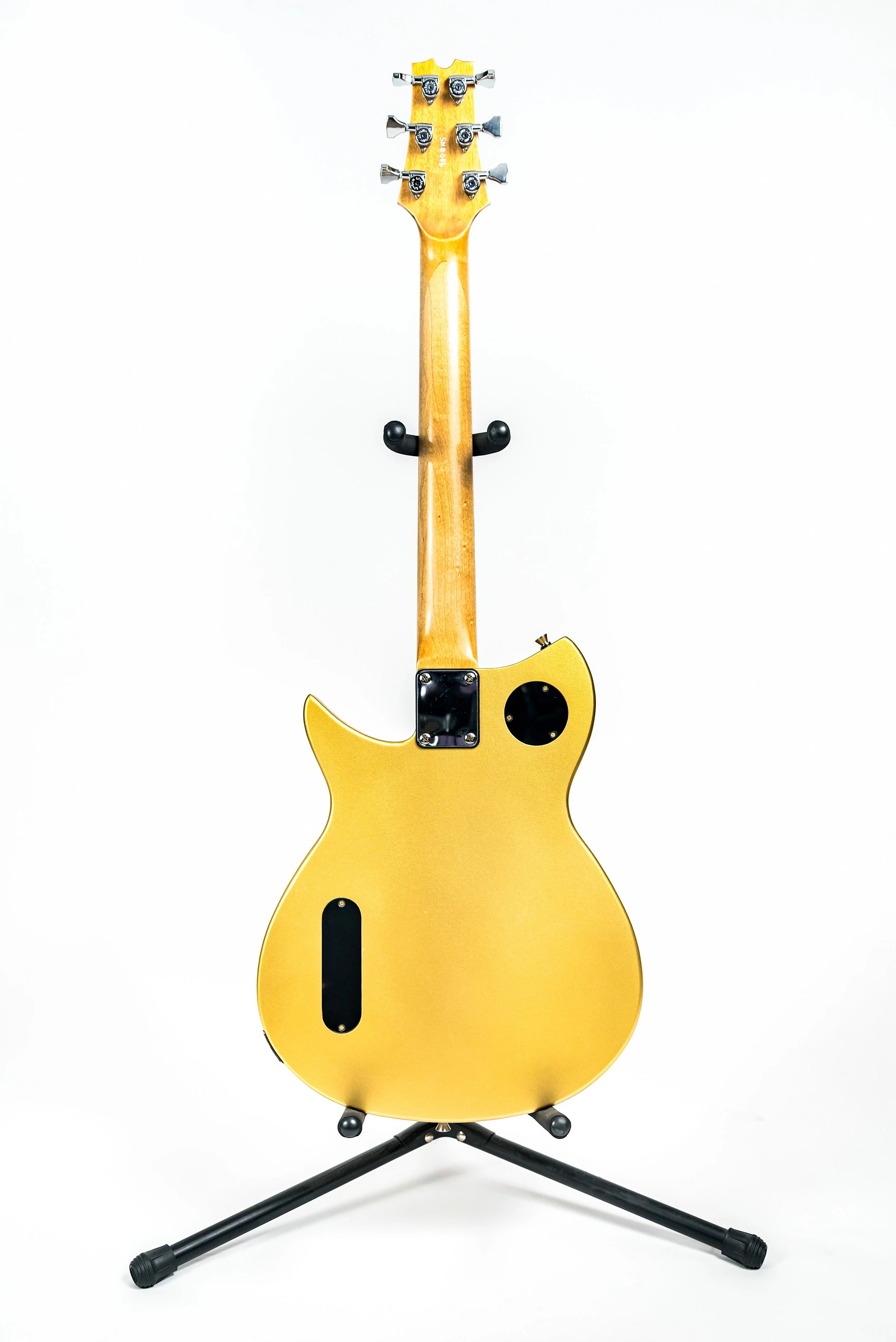 Yellow electric guitar on a black stand against a white background.