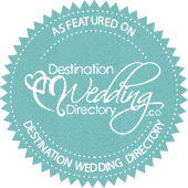 Blue circular badge with white text and decorative elements, featuring the words 'As Featured On Destination Wedding Directory.'