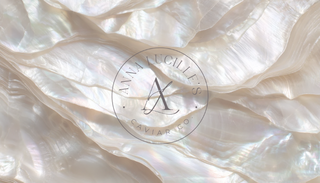 Close-up of mother-of-pearl or pearl-like surface with a circular logo for Anna Lucille's Caviar Co.