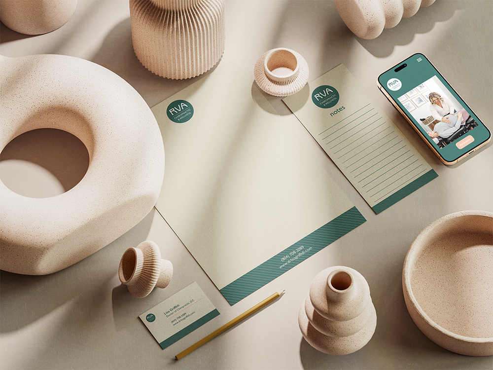 A collection of ceramic vases and bowls, a notepad, a business card, a pencil, and a smartphone on a table.