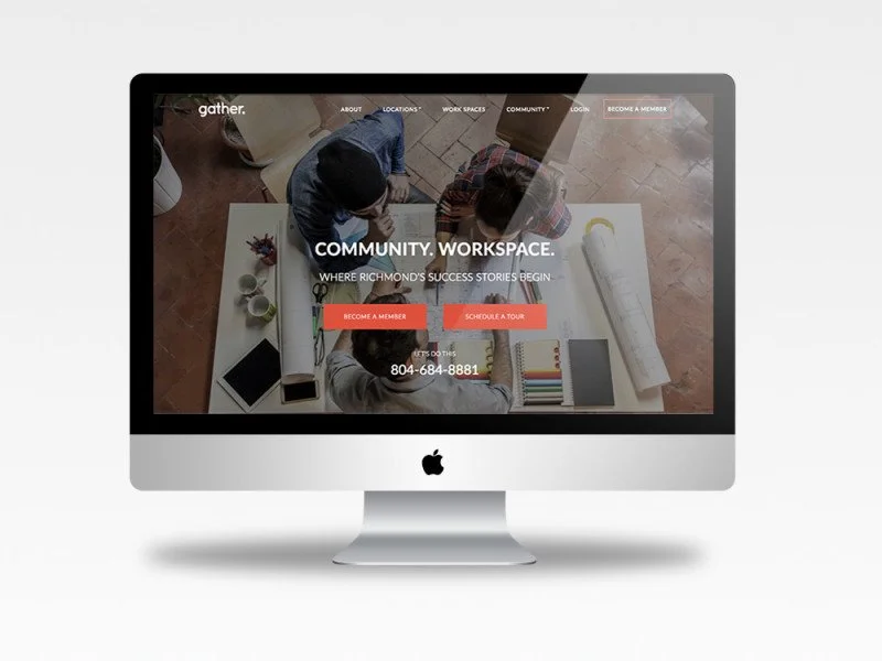 Computer screen displaying a community workspace website with buttons for membership and scheduling a tour, with people working at a table in the background.