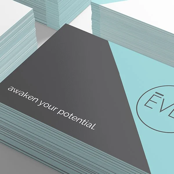 Stacked flyers or brochures with the text "awaken your potential." and an ev logo on a light blue background.