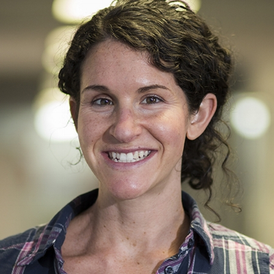 headshot of woman with dark hair and plaid collar 