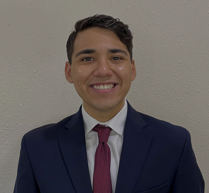 Headshot of man with dark hair, white collared shirt, dark suit jacket and red tie. 
