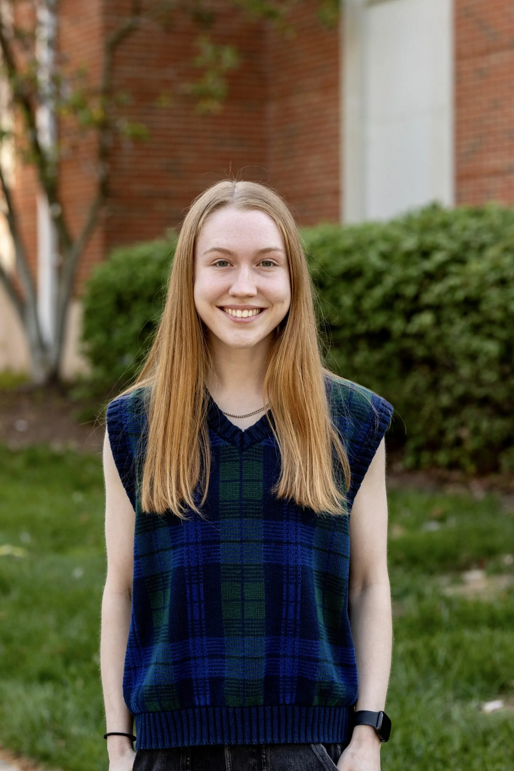 Woman with long blonde hair and blue plaid sweater.