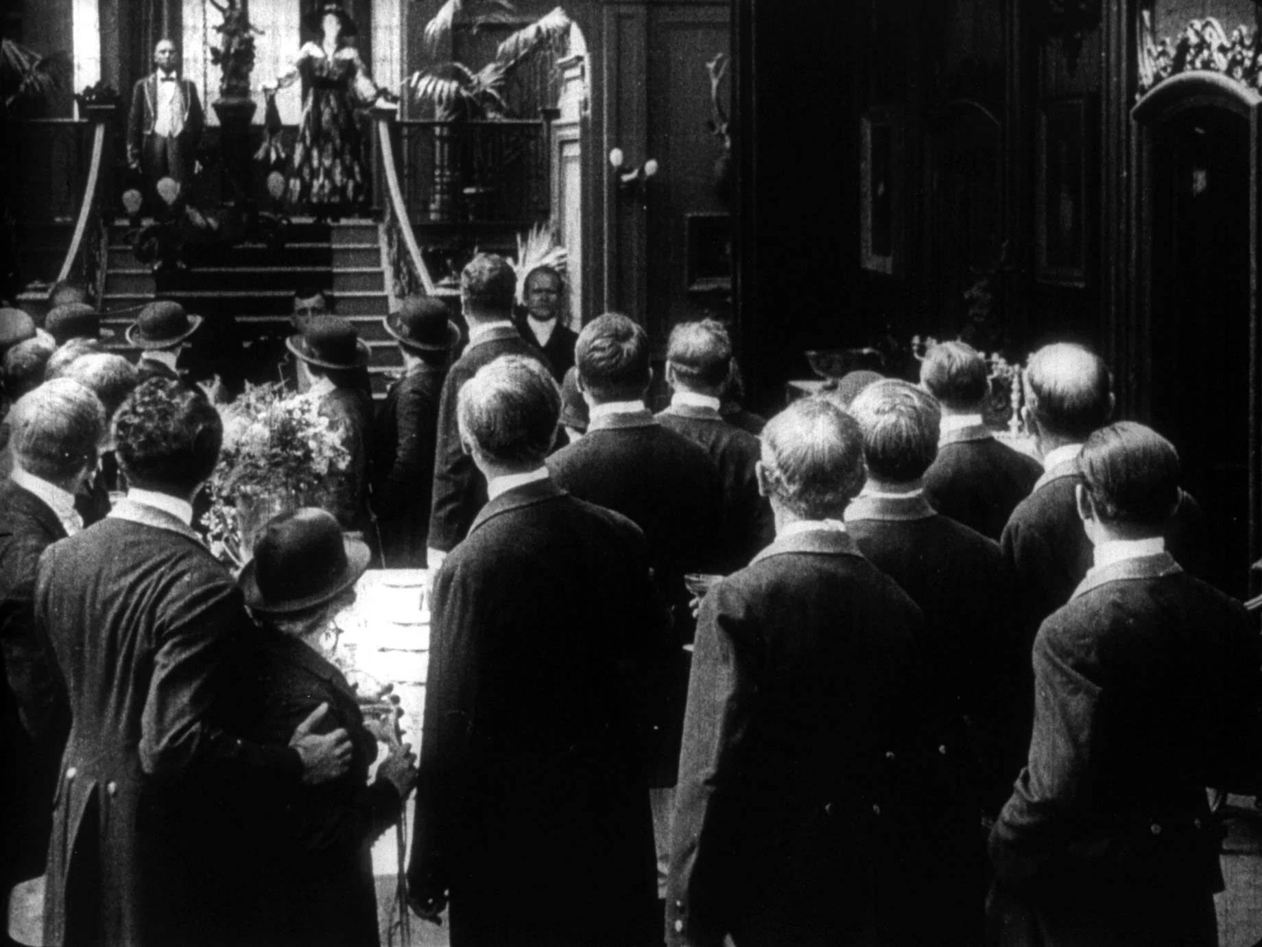 Mrs. D’Aquila stands high on the grand staircase to make her visually prominent in 1917 film version of The Whip directed by Maurice Tourneur. 