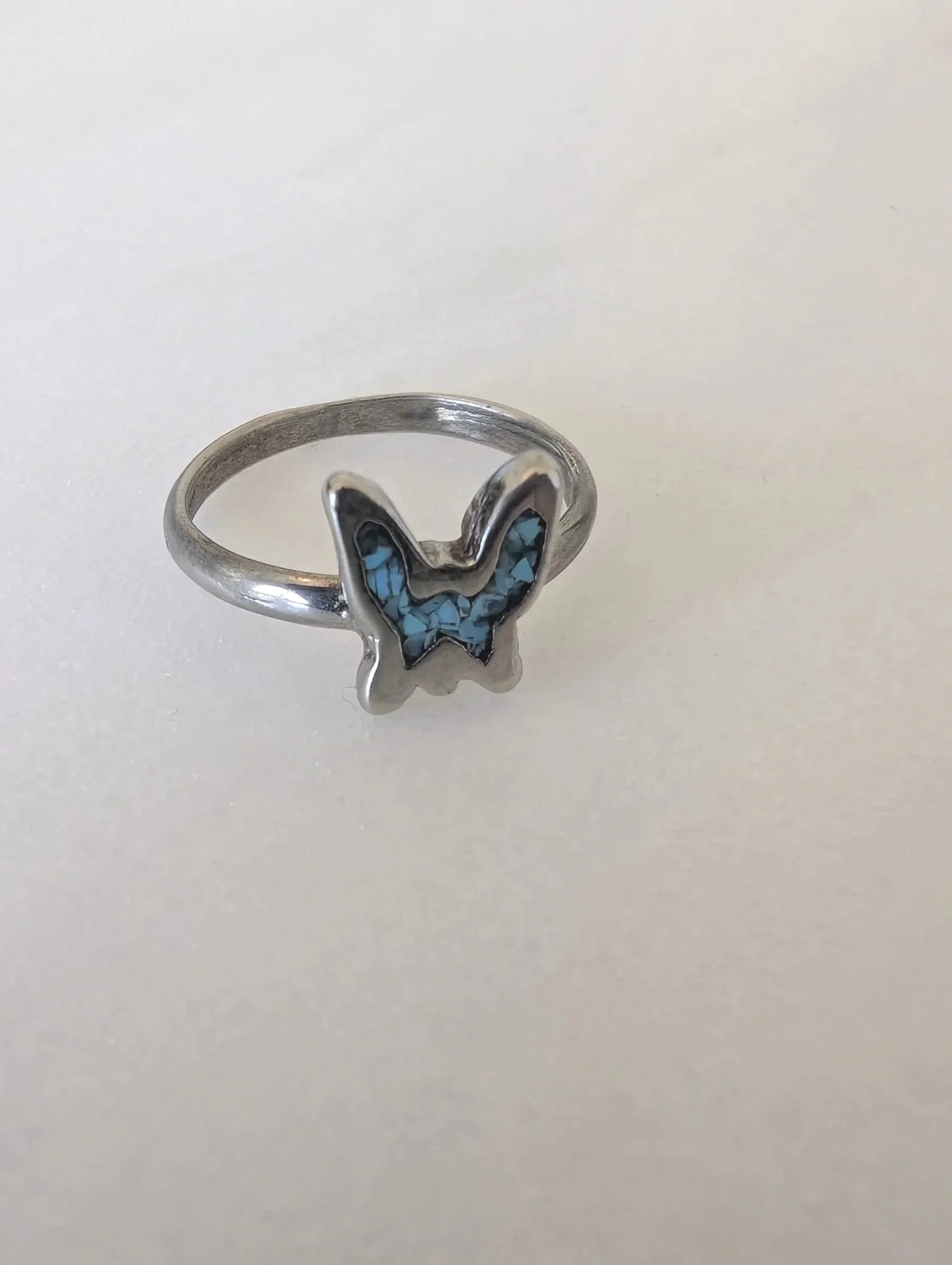 Silver ring with a butterfly-shaped inlay made of mosaic turquoise stones.