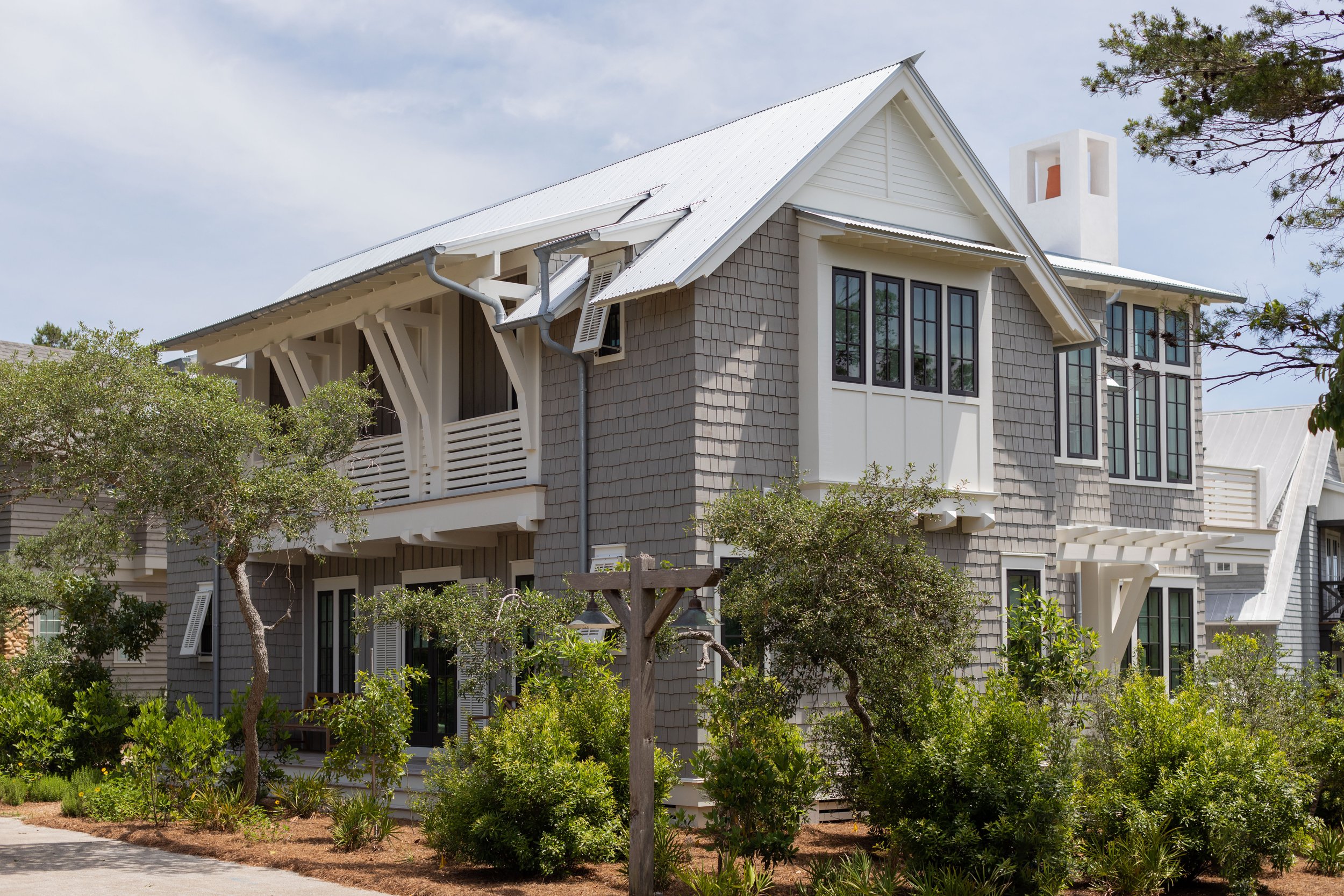 Coastal custom home exterior with shingle siding and covered porch