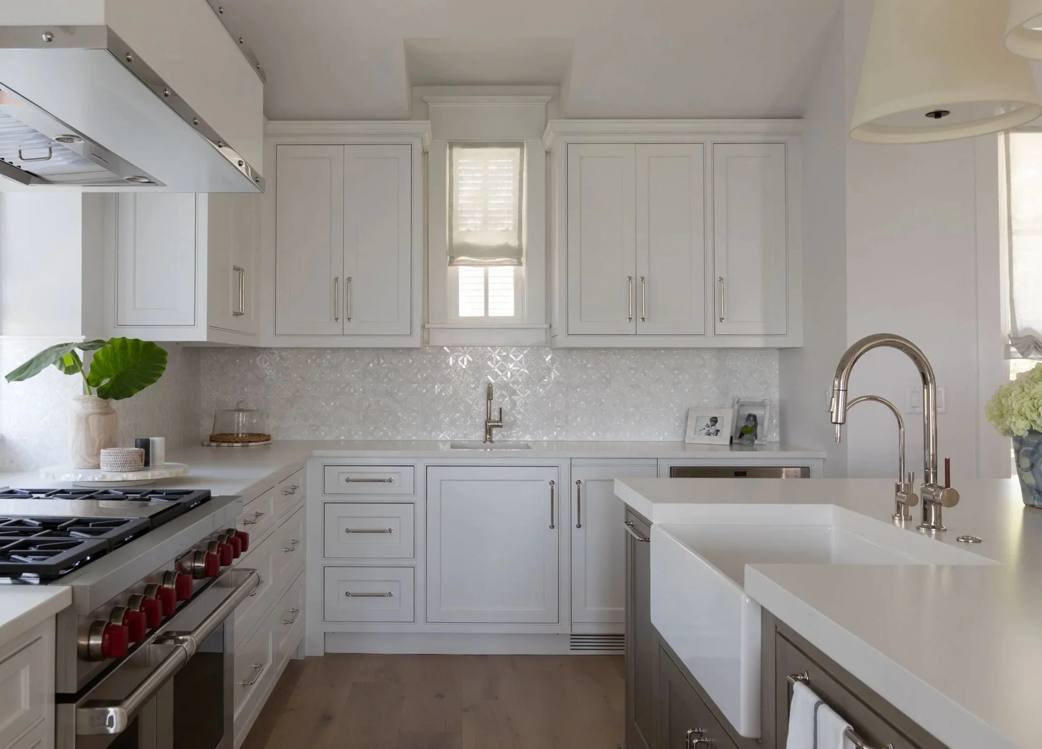 Custom white kitchen with marble backsplash and coastal finishes