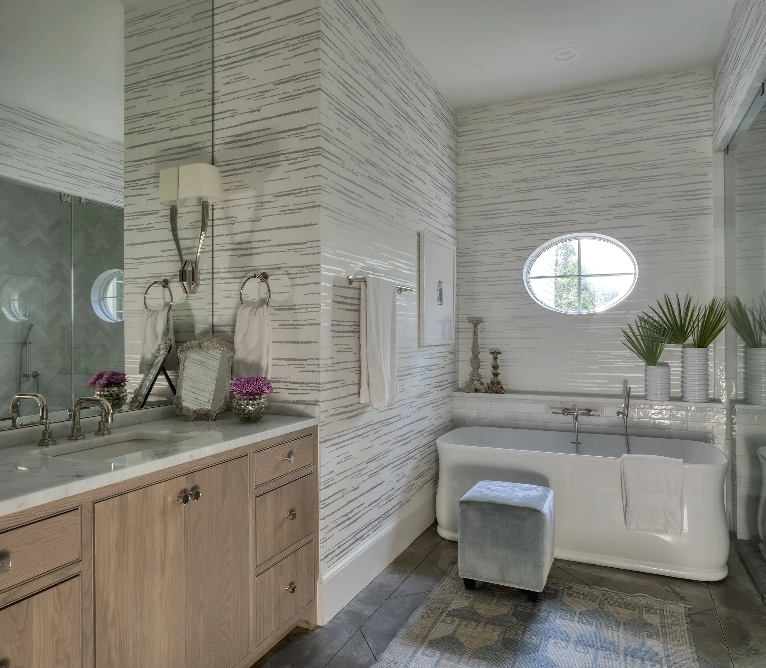 Custom coastal bathroom with marble tile and soaking tub