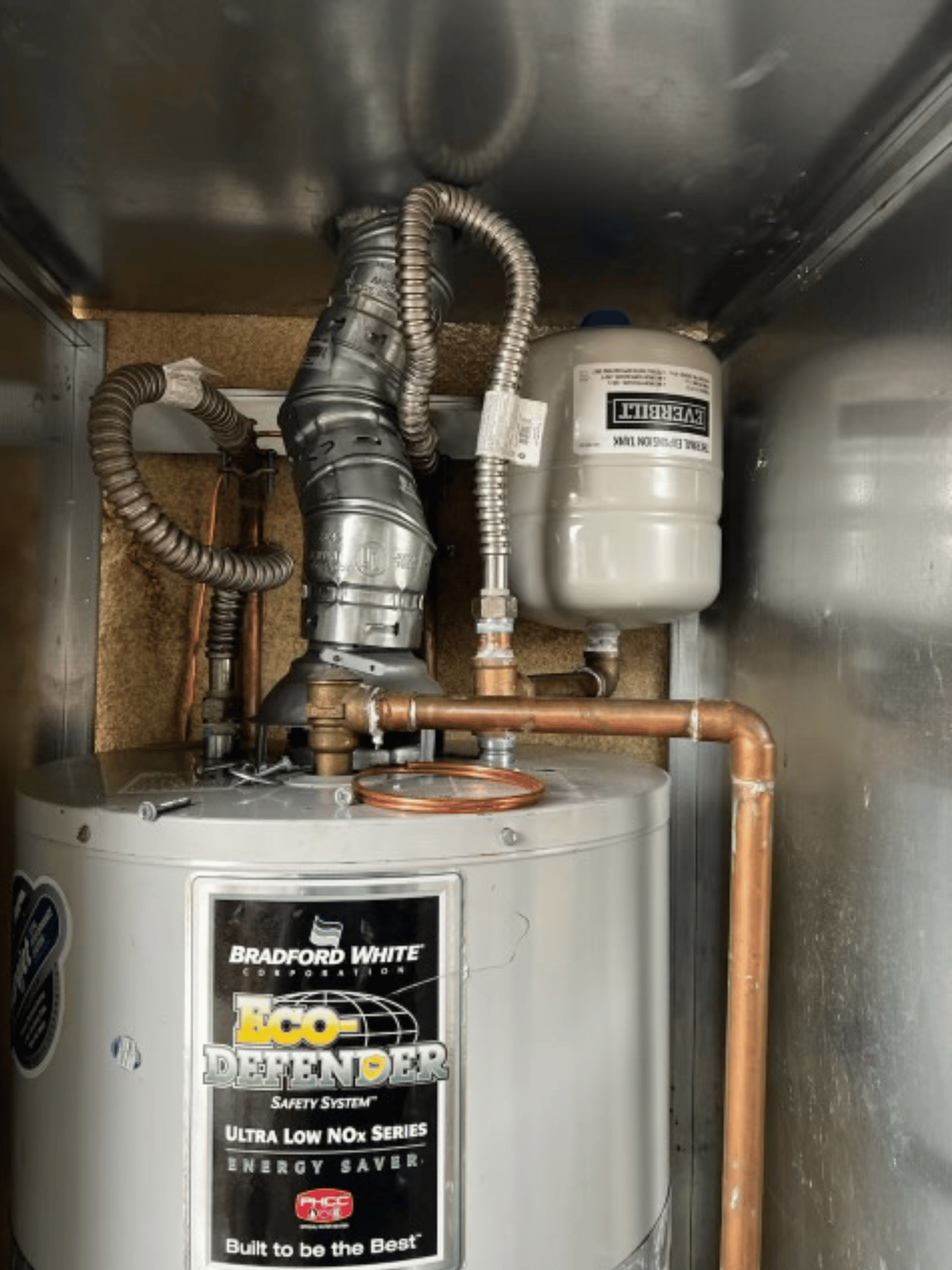 Chavez Plumbing technician repairing a residential water heater, inspecting valves and connections to restore safe hot water service.