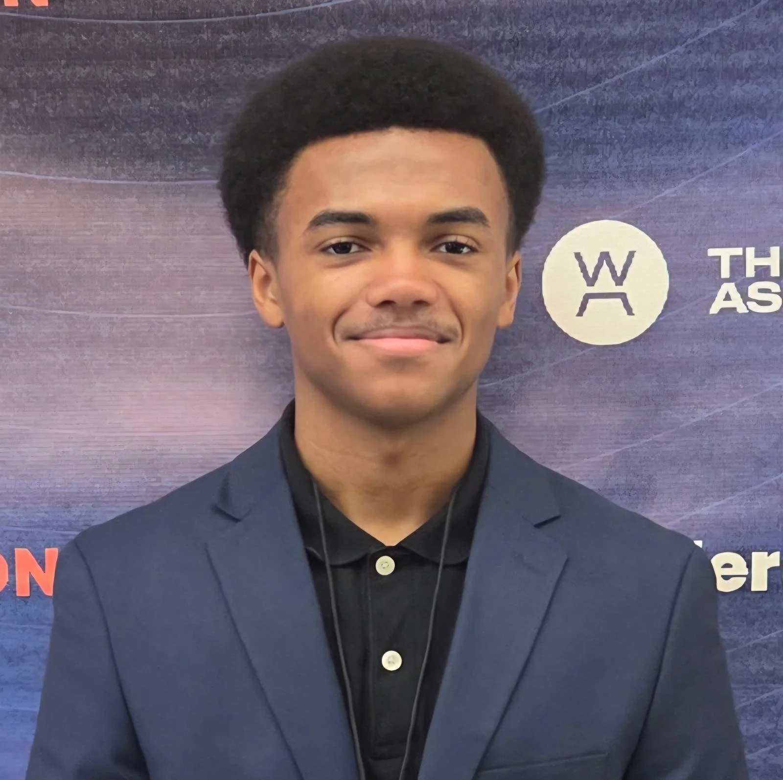 Young man in suit and tie standing in front of a modern building.