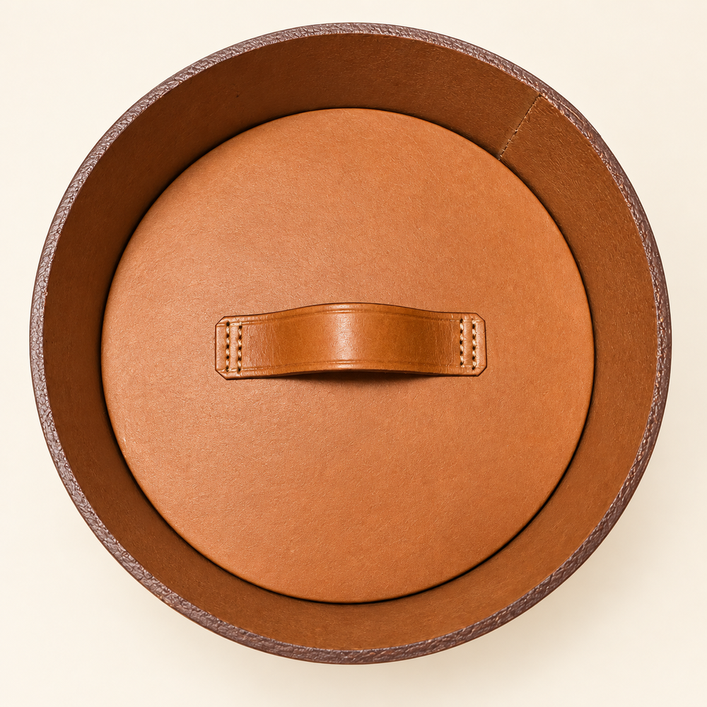 Top view of an open RQVM leather urn, showing the recessed inner lid and its handle