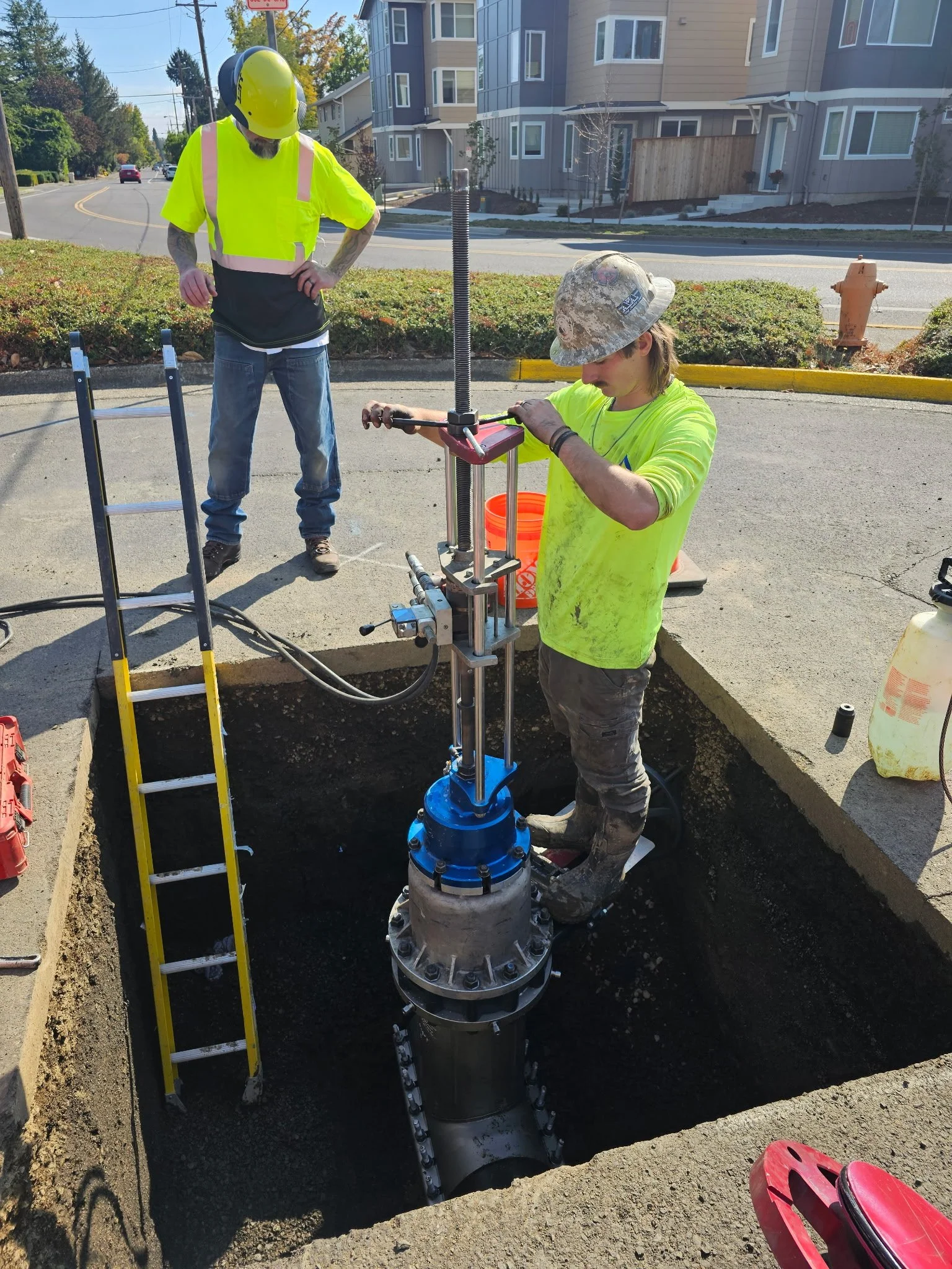 A&A Drilling worker installing a valve insertion on the side of a road.