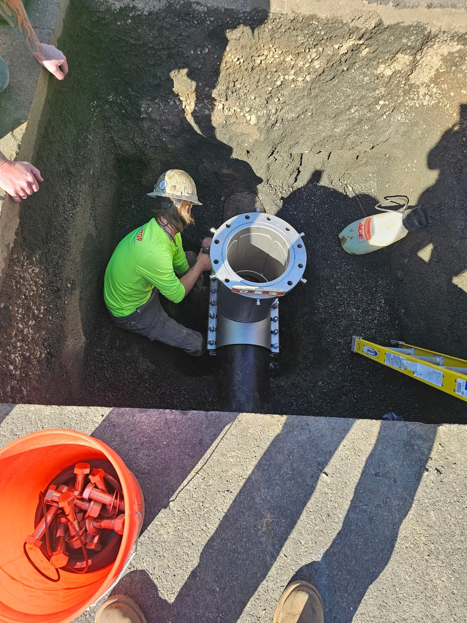 A&A Drilling worker installing a valve insertion on the side of a road.