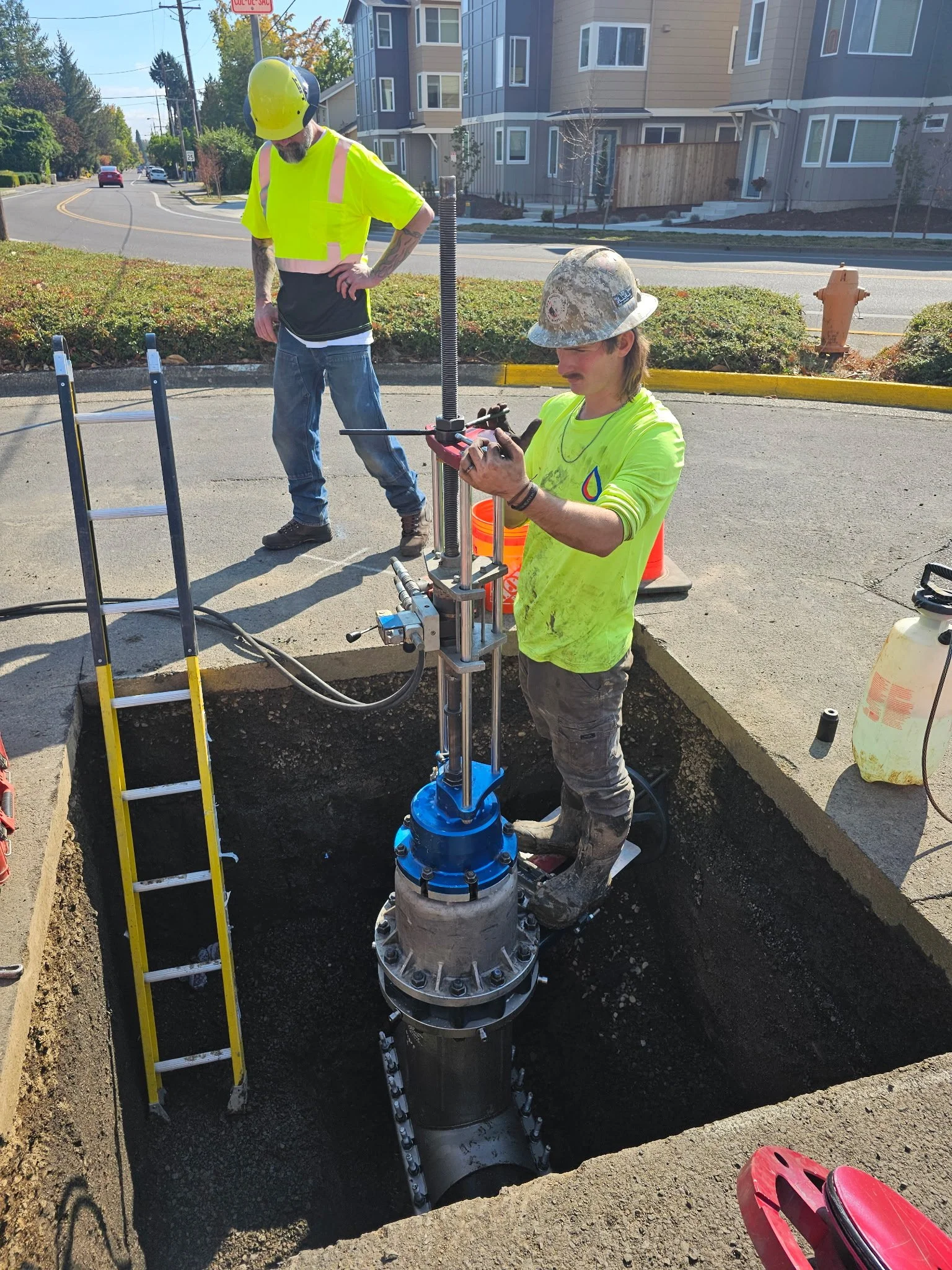A&A Drilling worker installing a valve insertion on the side of a road.