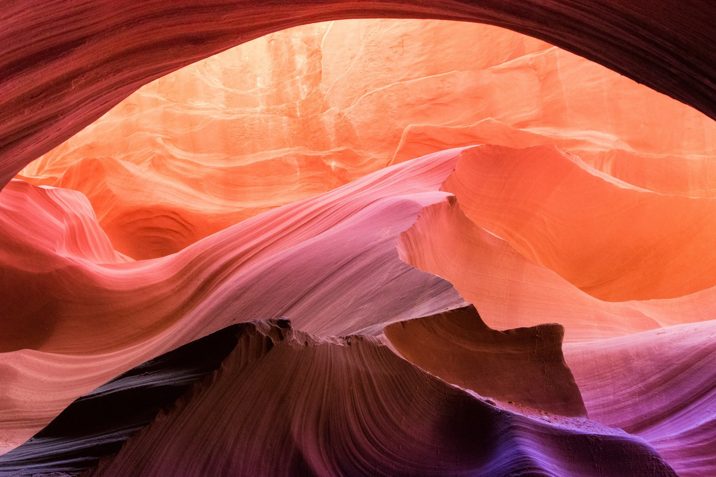 Flowing sandstone canyon walls in warm pink and orange tones with layered rock formations.