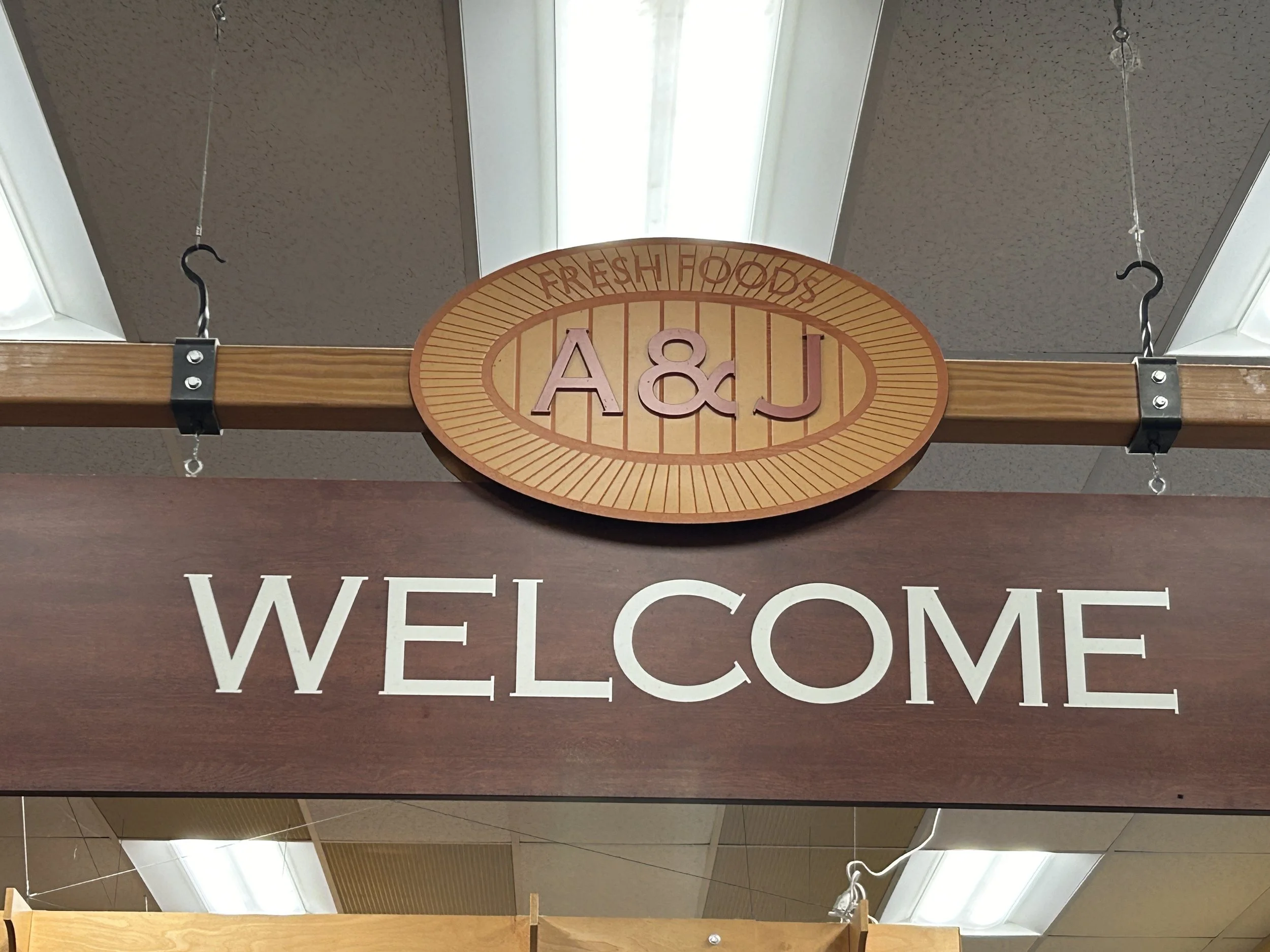 Entrance decorated with a wooden canopy and a welcome sign