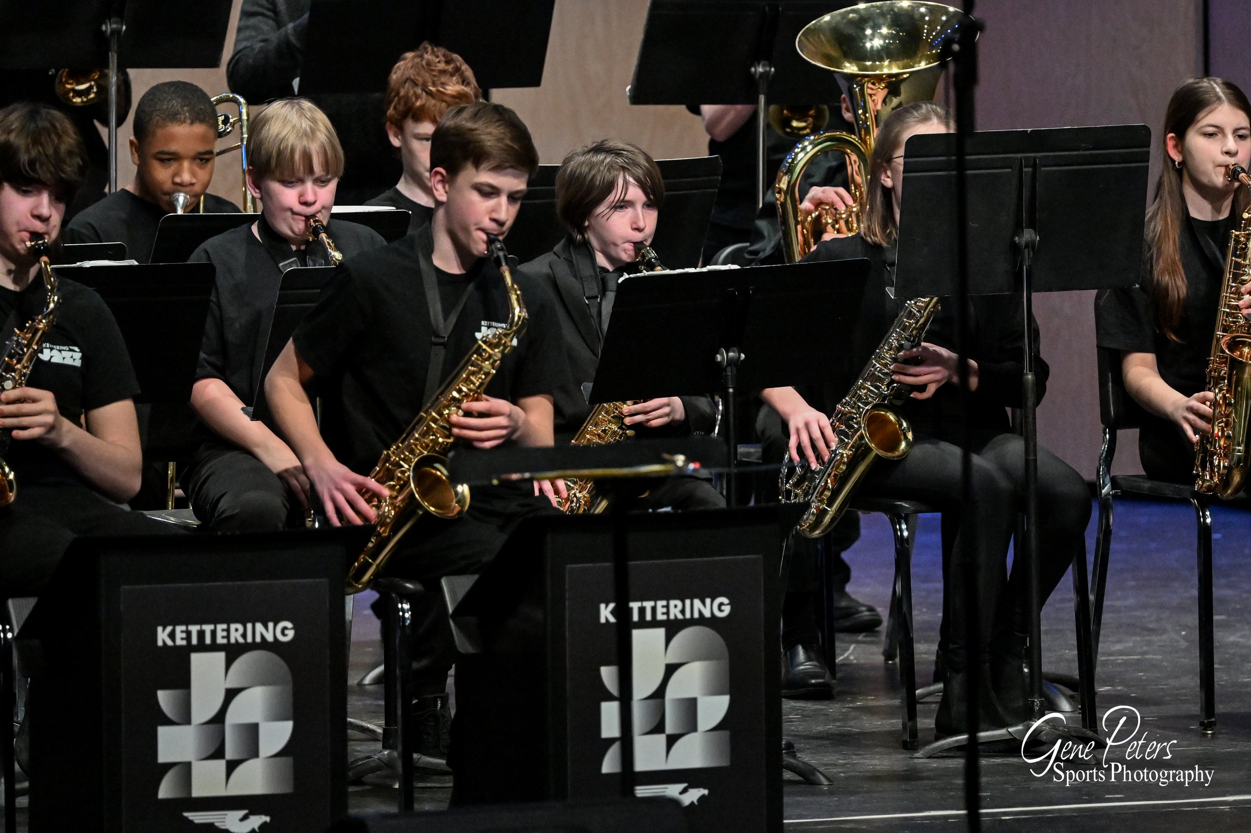 Young musicians playing saxophones during a concert on stage at Kettering.