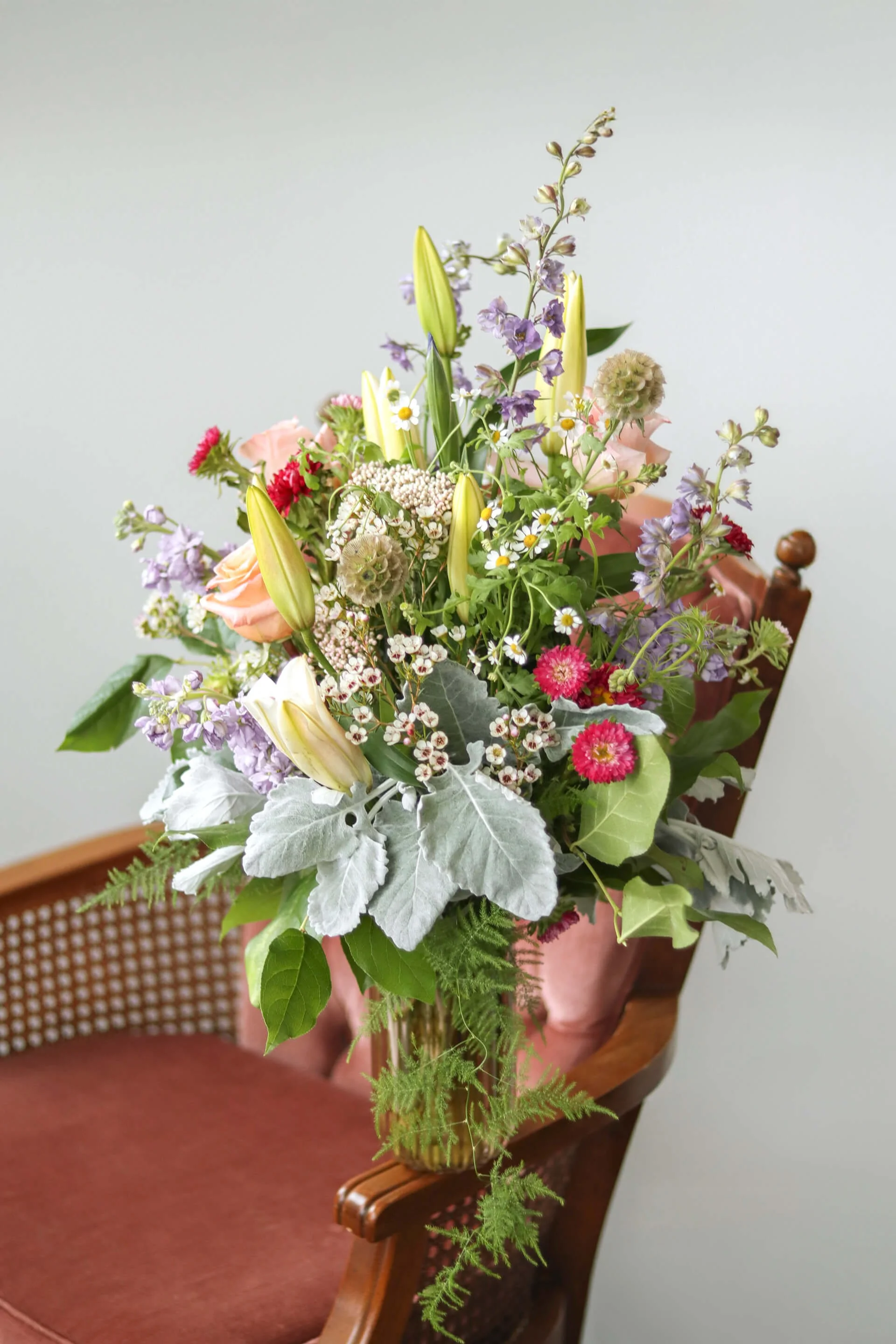 Floral bouquet pictured on an adorable rose colored antique chair