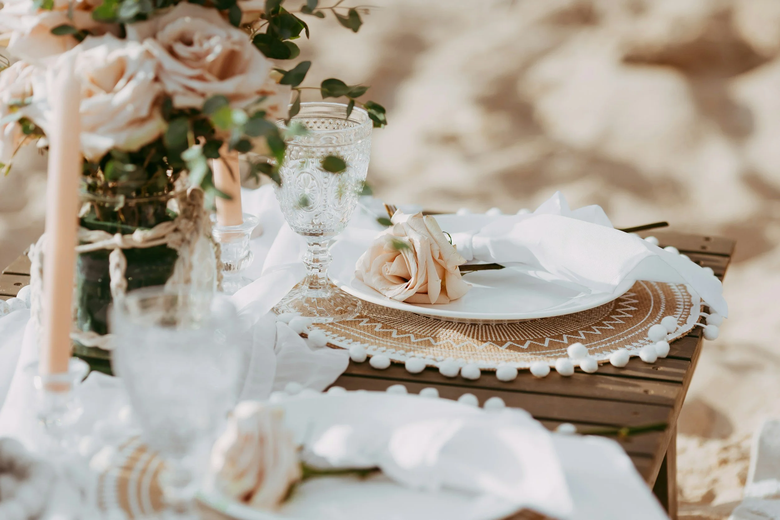 A candlelit table laid for dinner in golden light