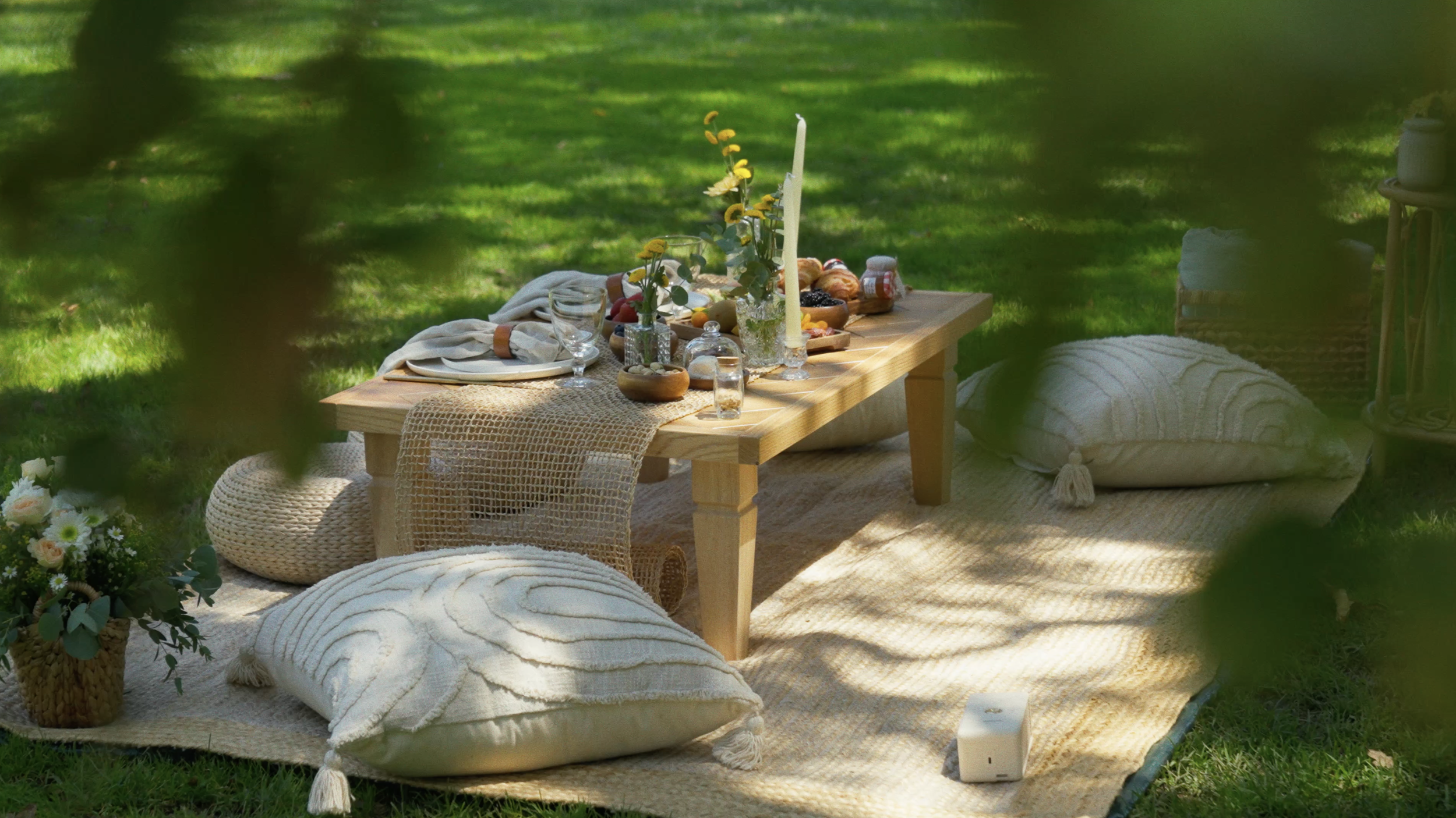 Low boho picnic table with flowers, candles and cushions — Mandra Soul outdoor date