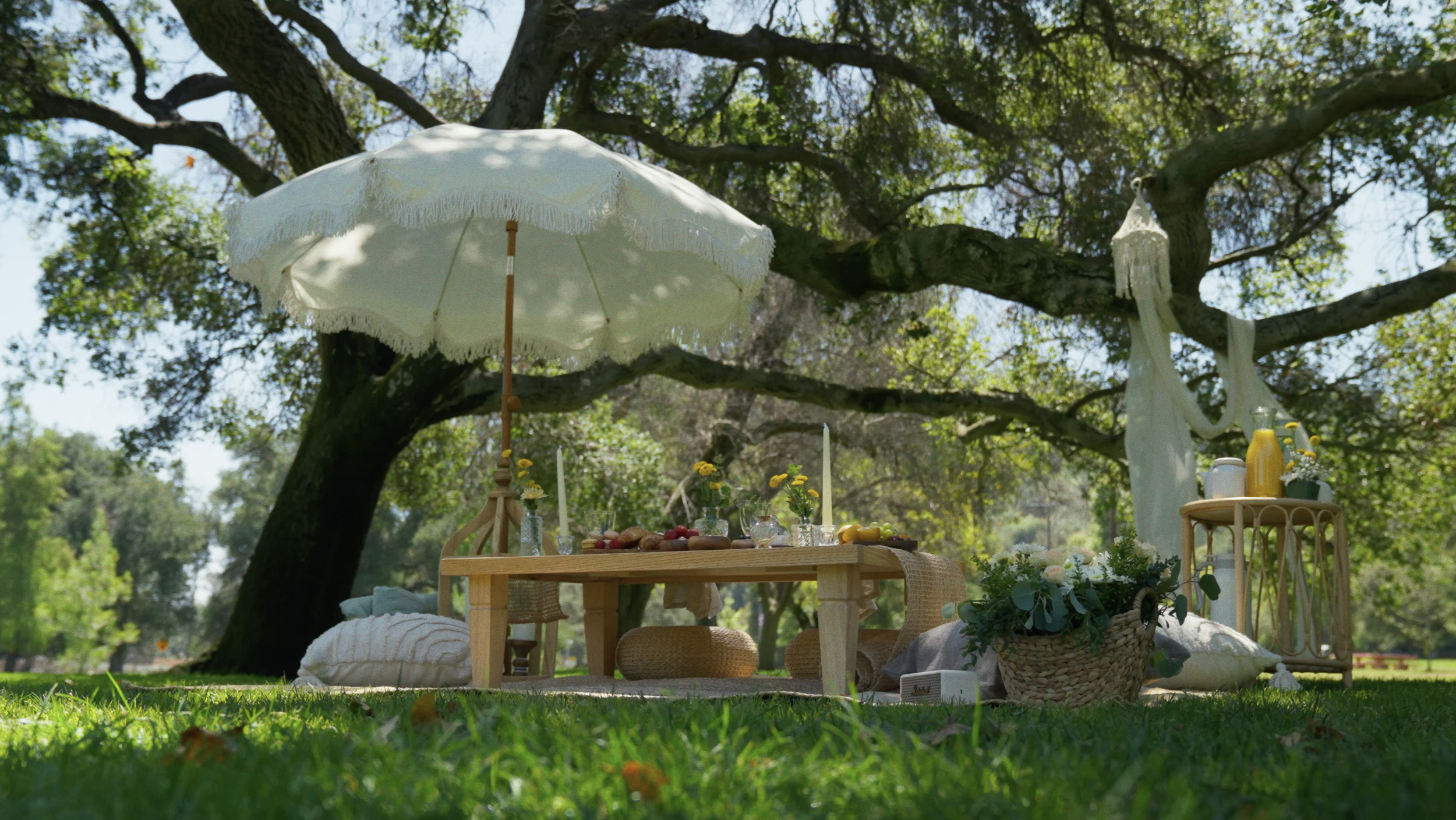 Outdoor picnic date with white umbrella, wooden table, flowers and drinks — Mandra Soul Los Angeles