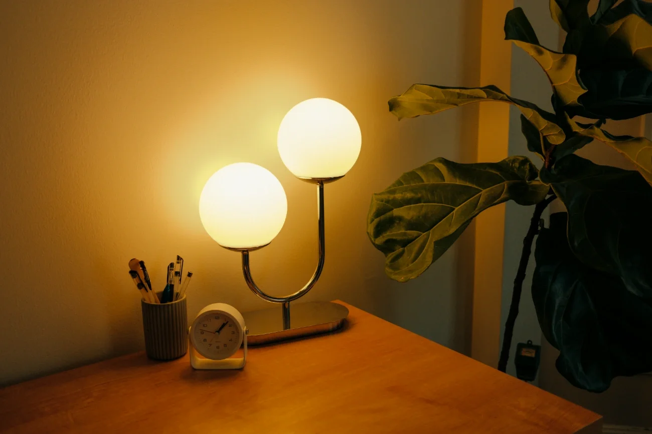 Lamp on table beside small desk clock and cup of pens in a therapist office