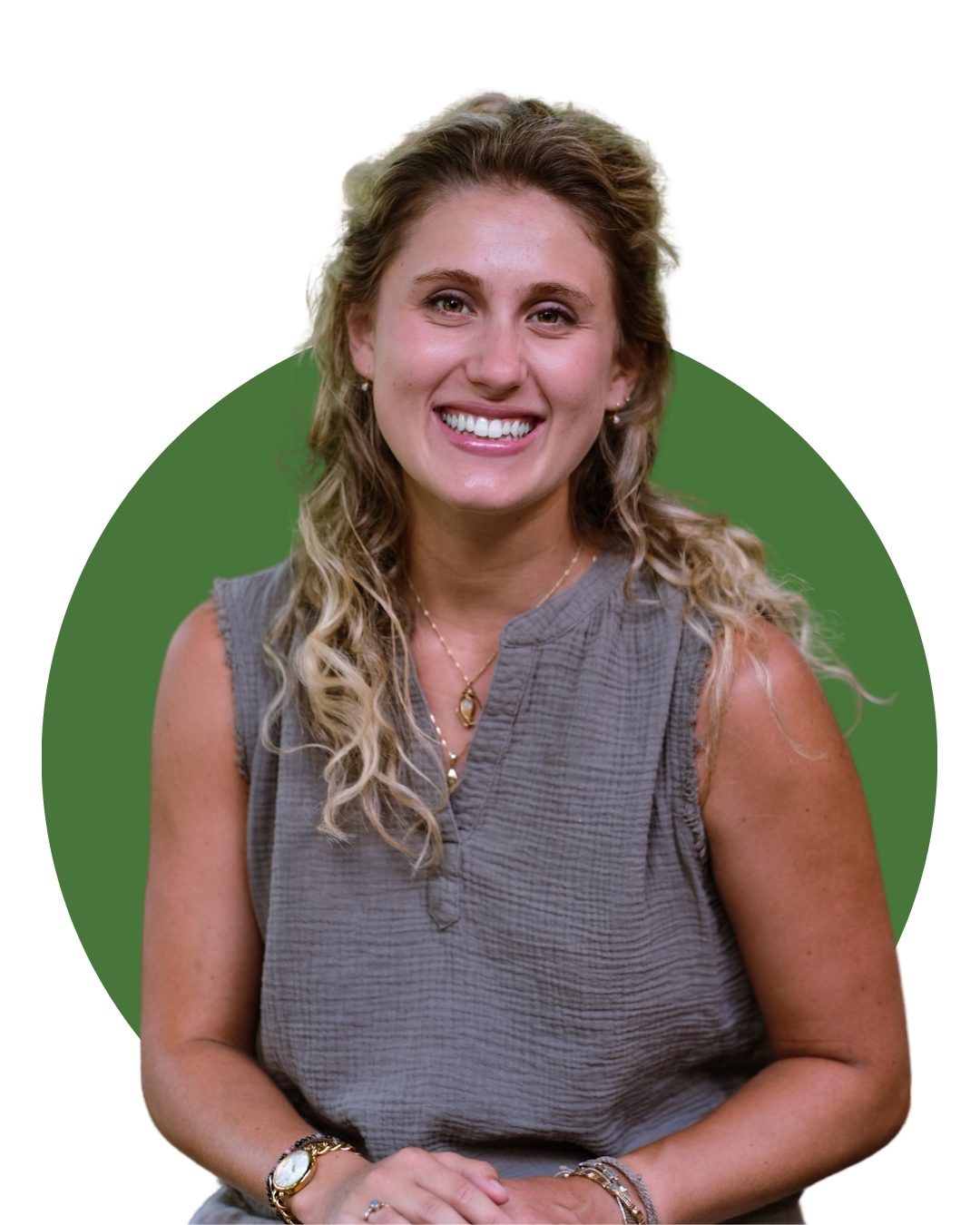 Headshot of Teagan Miller of Noia Wellness therapy in Hamilton sitting on a chair, in front of a rustic fireplace with plants on top