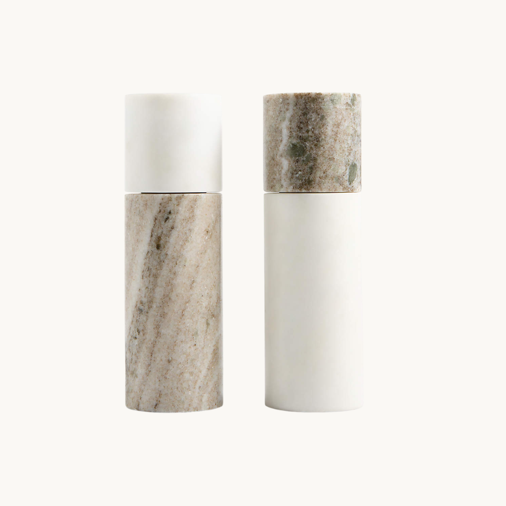 Two pairs of cylindrical marble containers with lids, one pair with a smooth white finish and the other with a textured, multi-colored, speckled finish, standing on a white background.