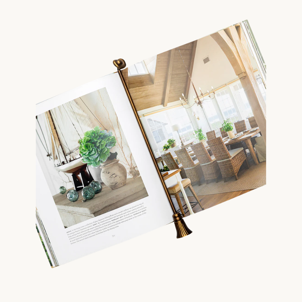 Open book displaying interior decor with a potted plant and glass ornaments on a shelf, and a dining area with a chandelier, wicker chairs, and potted plants on the table.