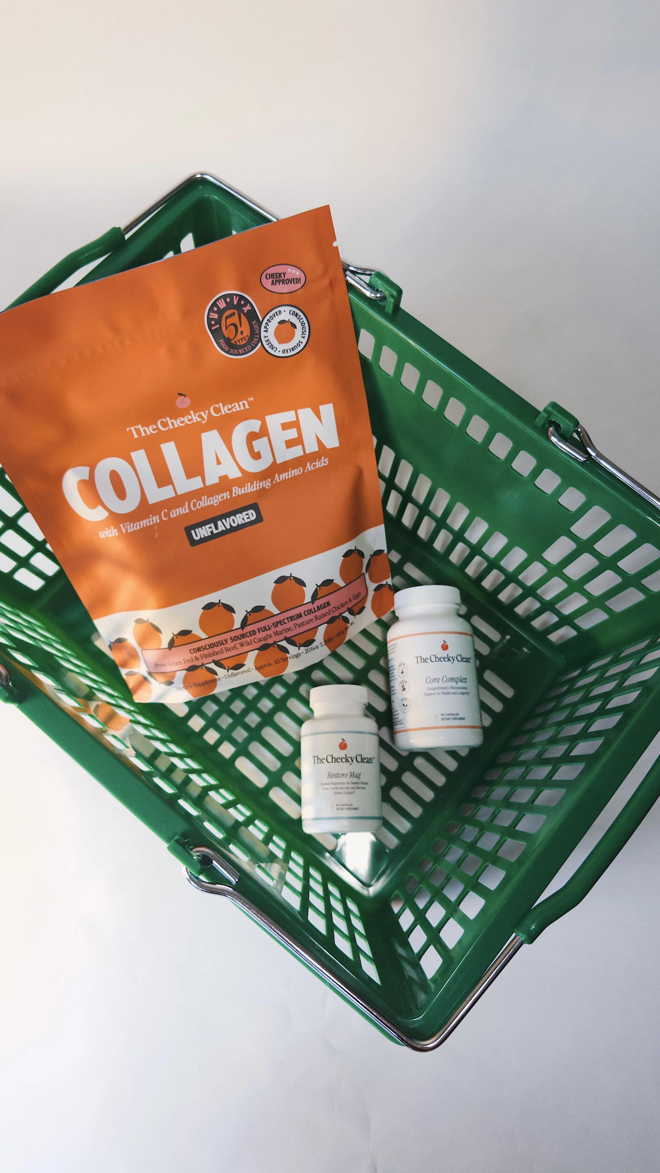 A green shopping basket contains a packet of collagen powder and two white bottles of dietary supplements.