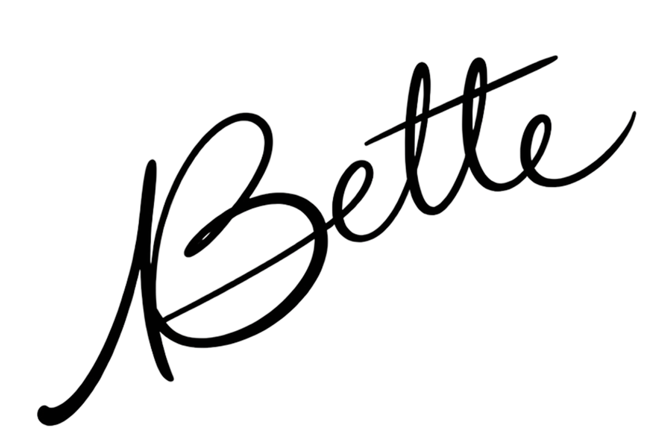 Texto en estilo cursiva que dice 'Bettie' con una línea diagonal que atraviesa la palabra.