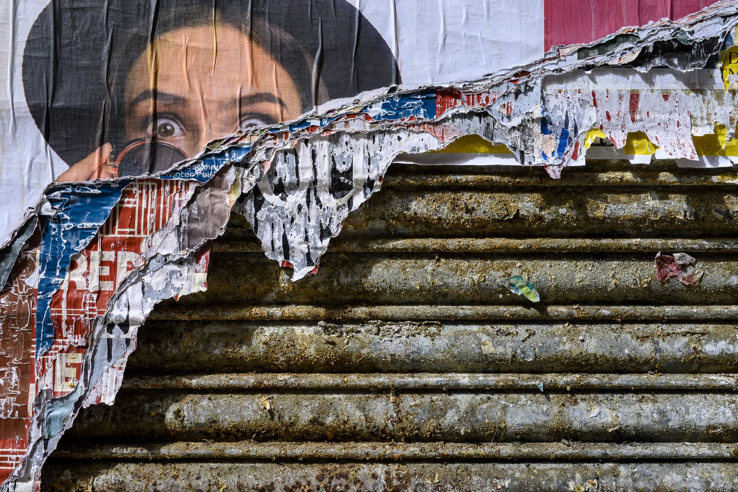 Carteles y una vieja persiana de una tienda