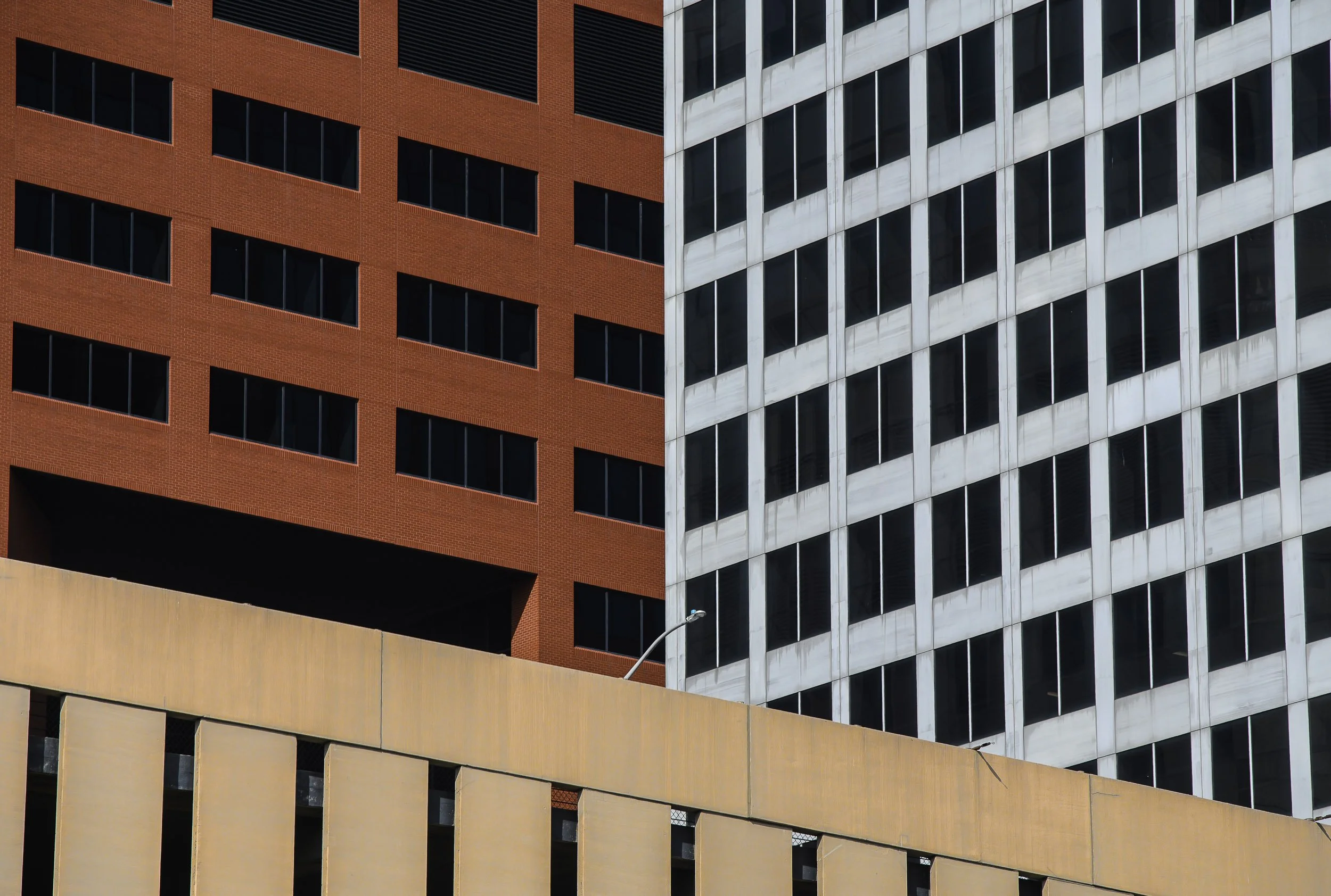 Vista de edificios altos con ventanas en diferentes colores y estilos, incluyendo una estructura de pared amarilla en primer plano.
