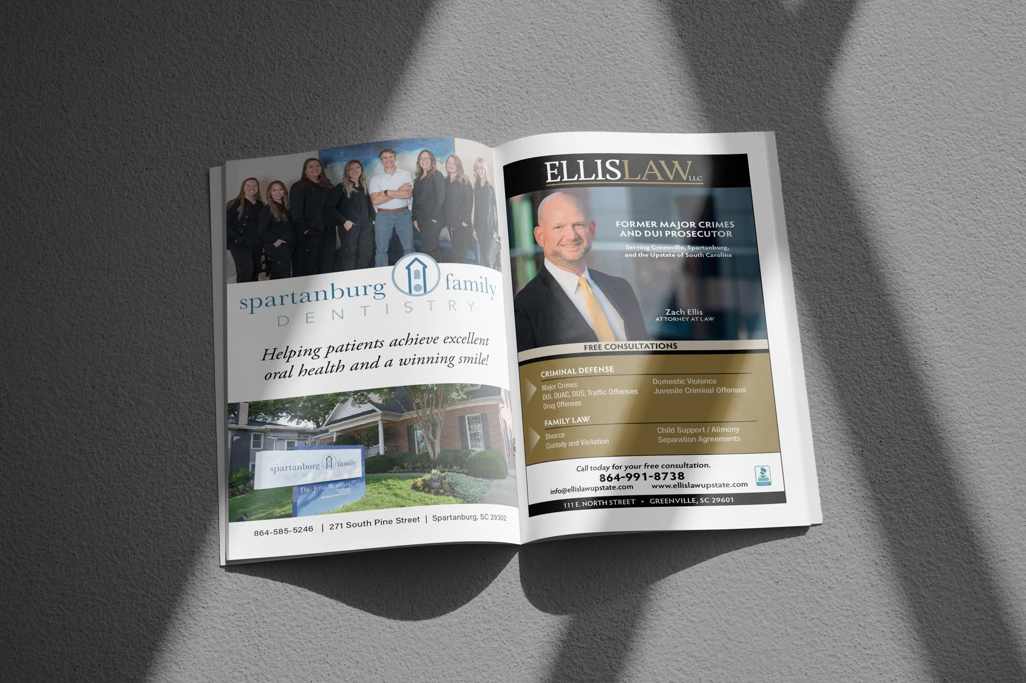 Open magazine with advertisements for a law firm and a dental practice, featuring photos of staff and a house, on a gray textured surface with shadow.