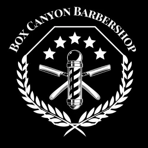 Black and white logo for Box Canyon Barbershop featuring a traditional straight razor, a safety razor, and a barber pole inside a shield with a laurel wreath and five stars around the shield.