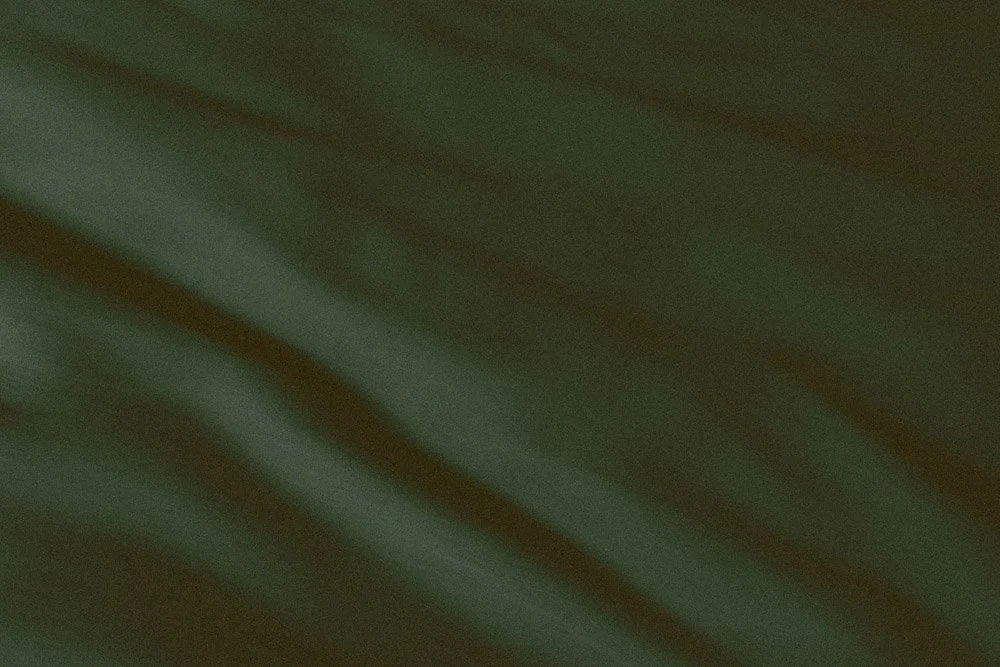 Textured green background of loosely woven rippled fabric