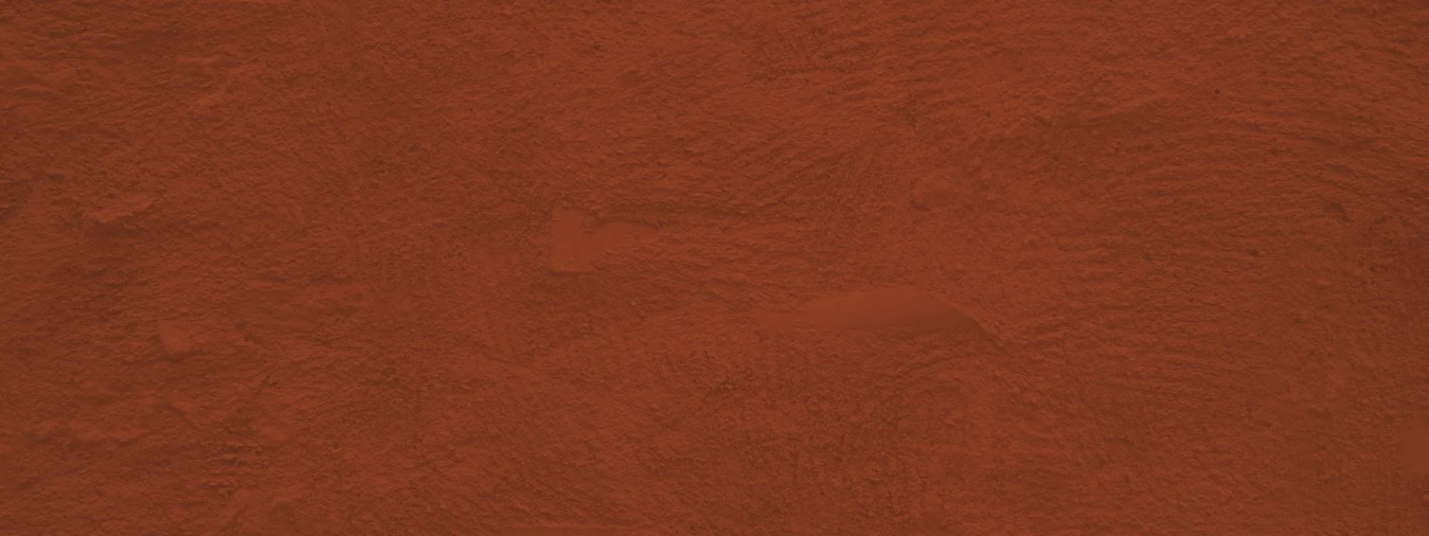 Close-up of a textured orange-brown wall with visible rough surface and patches.