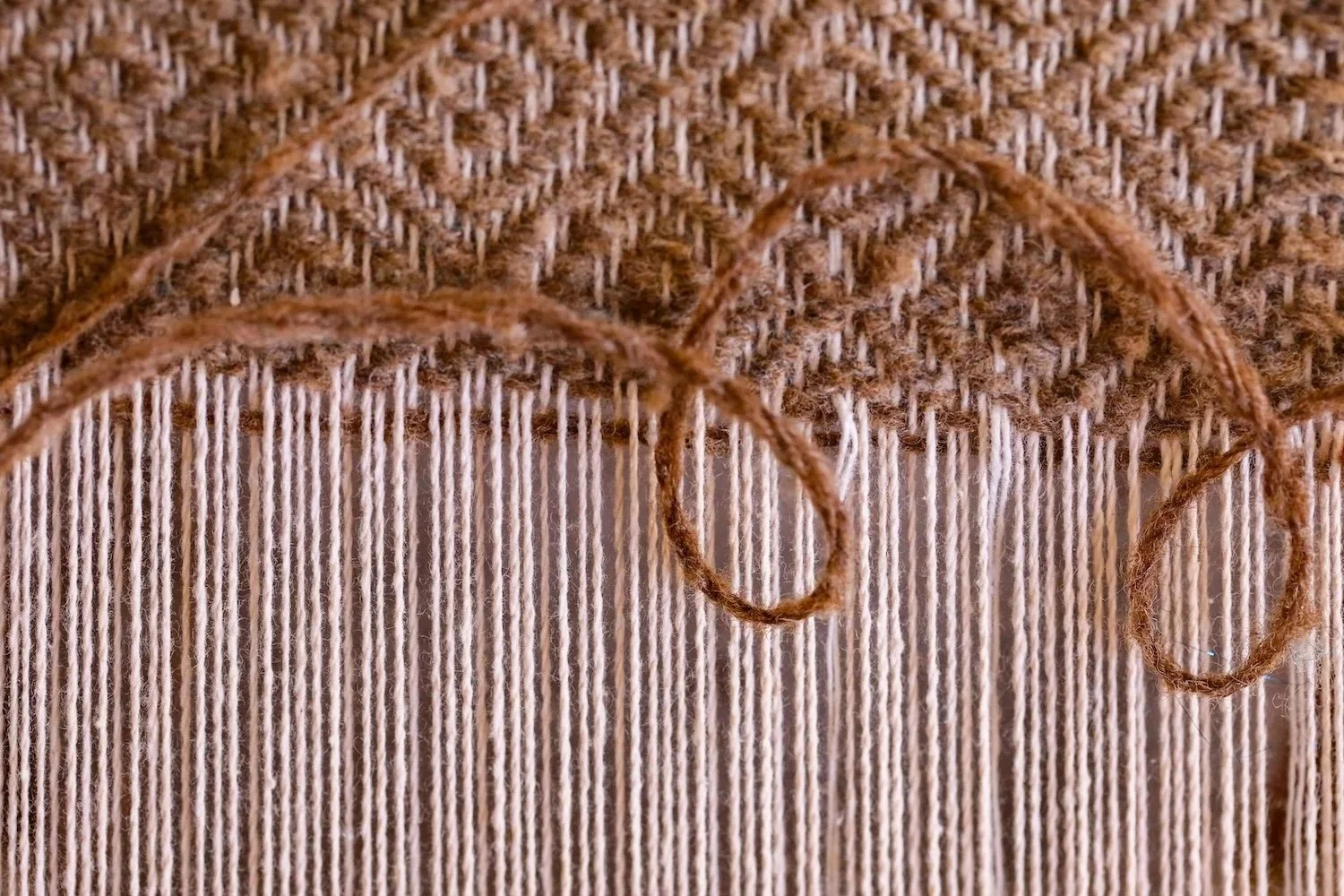 Detail of woven fibers with rust colored yarn.