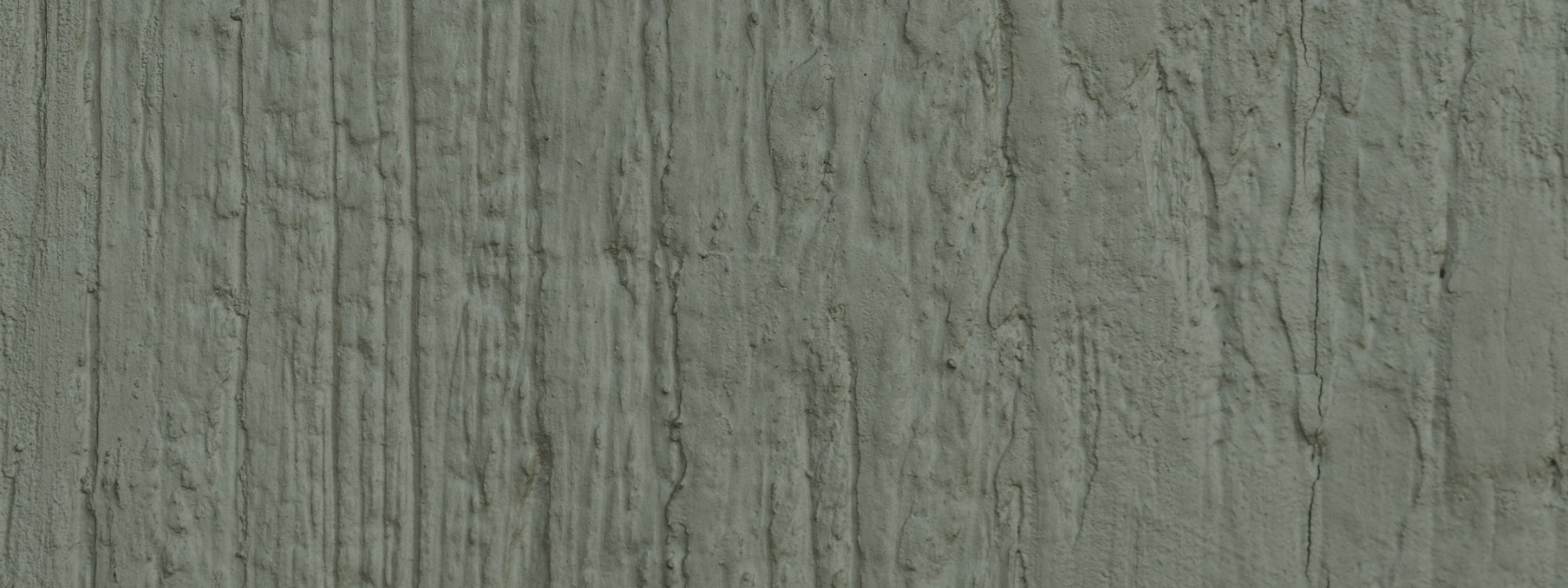 Detail view of textured stone with vertical streaks and cracks.