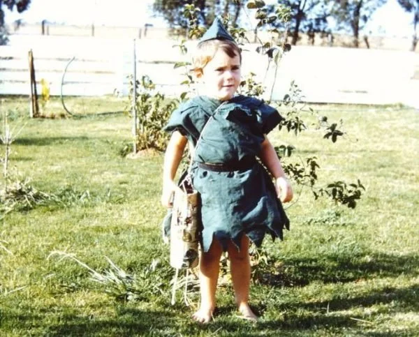 Mandy Jackson-Beverly as a child, dressed in a homemade Peter Pan costume standing in a backyard garden